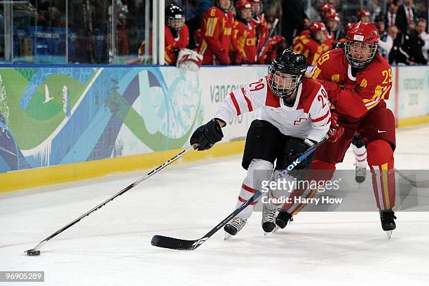 Melanie Hafliger of Switzerland handles the puck against Fujin Gao of China during the ice hockey women's preliminary game on day nine of the...