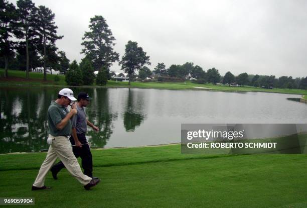 Miguel Angel Jimenez of Spain lights up a cigar as he walks with his friend Jose Maria Olazalbal also of Spain of the Atlanta Athletic Club in...