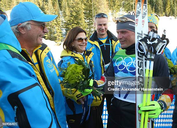 Swedish King Carl Gustaf and Swedish Queen Silvia interact with Tobias Angerer of Germany after he captured the Silver medal in the Men's 30 km...
