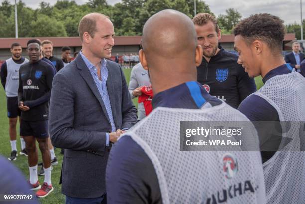 Prince William, Duke of Cambridge chats to England players including Captain Harry Kane as he attends the Facility at the FA Training Ground to meet...