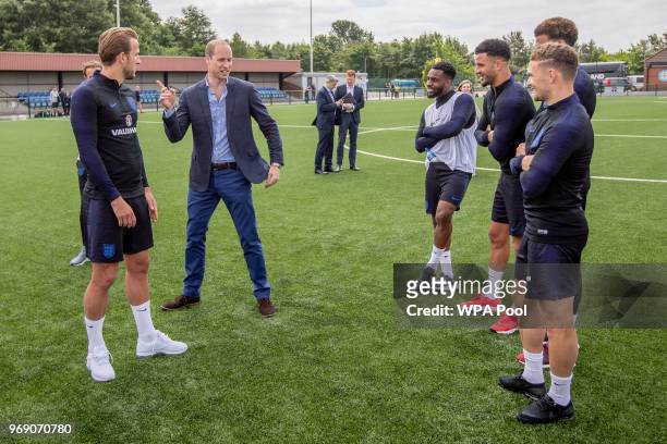 Prince William, Duke of Cambridge chats to England players including Captain Harry Kane as he attends the Facility at the FA Training Ground to meet...