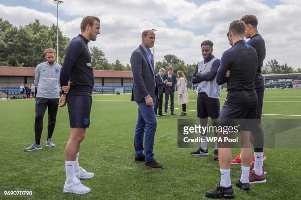Prince William, Duke of Cambridge chats to England players including Captain Harry Kane as he attends the Facility at the FA Training Ground to meet...