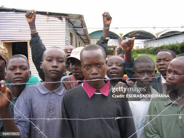 Demobilized child soldiers stand 10 December 2004 behind barbed wire in rehabilitation centre in Gitega, Burundi. The process of demobilization of...