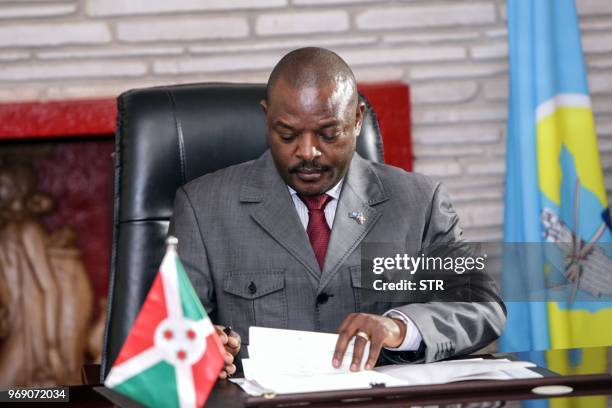 Burundi's President Pierre Nkurunziza signs for a new constitution adopted by a referendum in Gitega, Burundi, on June 7, 2018. - The constitution,...