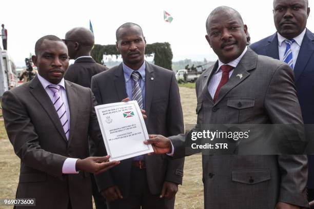 Burundi's President Pierre Nkurunziza and President of the Constitutional Court Charles Ndagijimana , pose with the new constitution adopted by...