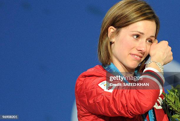 Canada's silver medalist Jennifer Heil wipes her eye during the medals ceremony on the podium of the Women's Moguls Freestyle Skiing event in...