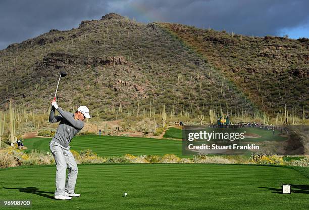 Camilo Villegas of Columbia plays his tee shot on the 15th hole as a rainbow appears during round four of the Accenture Match Play Championship at...