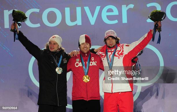 Martins Dukurs of Latvia receives the silver medal, Jon Montgomery of Canada receives the gold medal and Alexander Tretyakov of Russia receives the...
