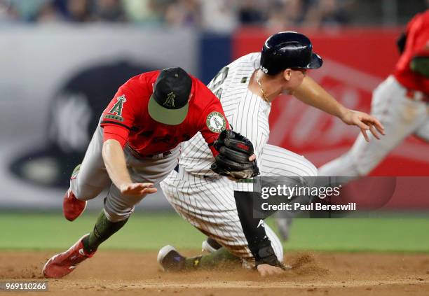 Aaron Judge of the New York Yankees safely reaches second base and moves to third as Zack Cozart of the Los Angeles Angels can't handle the errant...