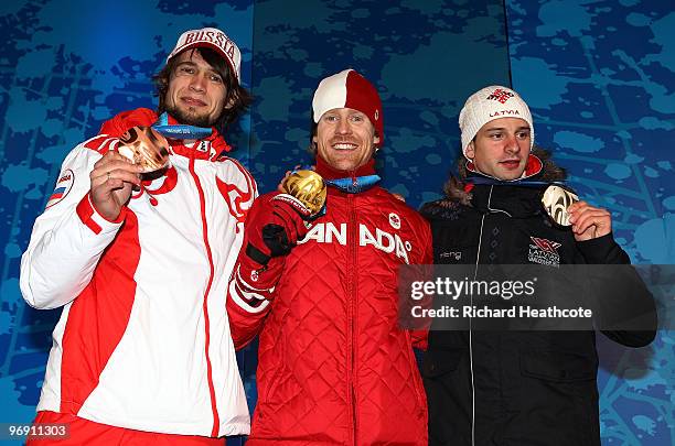 Alexander Tretyakov of Russia receives the bronze medal, Jon Montgomery of Canada receives the gold medal and Martins Dukurs of Latvia receives the...