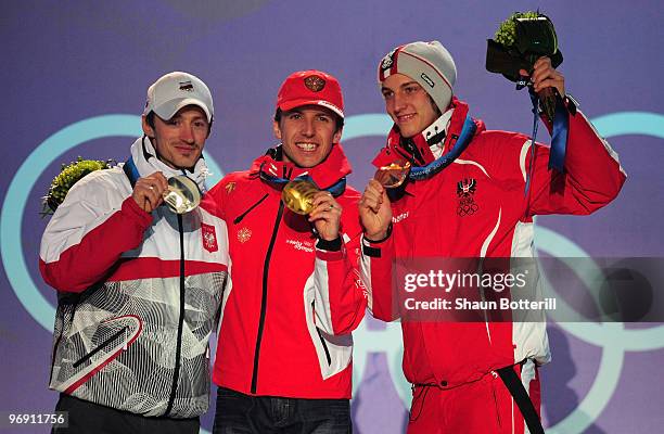 Adam Malysz of Poland receives the silver medal, Simon Ammann of Switzerland receives the gold medal and Gregor Schlierenzauer of Austria receives...