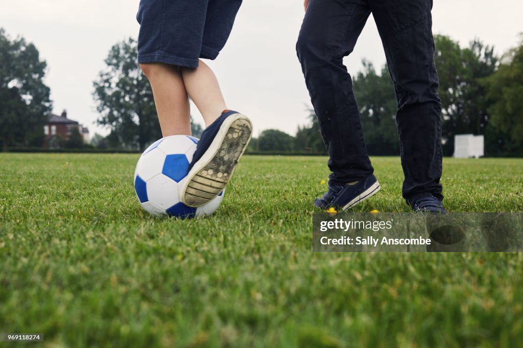 Two boys playing football together