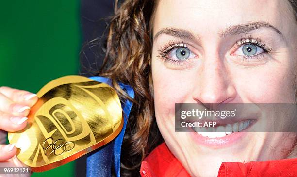 Britain's gold medalist Amy Williams displays her medal on the podium during the medal ceremony of the women's skeleton final event of the Vancouver...