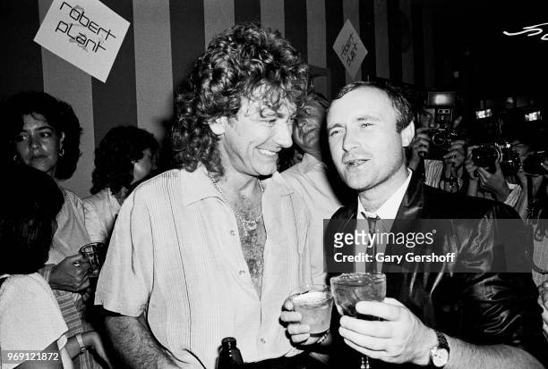 View of British Rock musicians Robert Plant and Phil Collins as they attend an after party at Greenwich Village's Be Bop Club, New York, New York,...