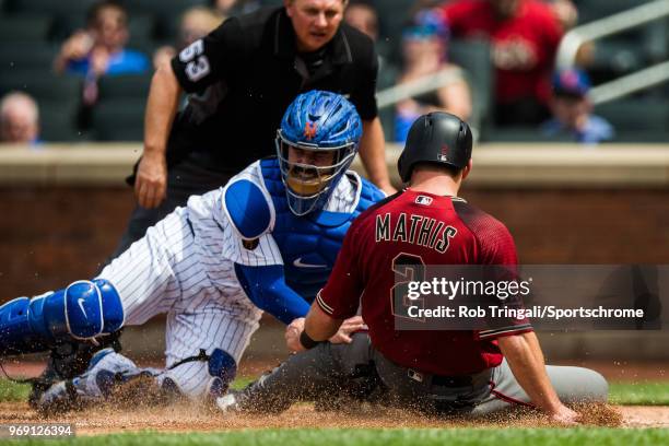 Tomas Nido of the New York Mets tags out Jeff Mathis of the Arizona Diamondbacks at home plate during the game at Citi Field on Sunday May 20, 2018...