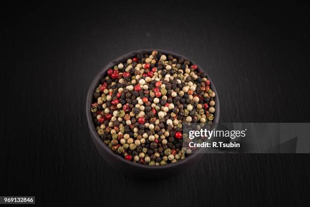 bowl of various pepper peppercorns seeds mix on dark stone - allspice stock pictures, royalty-free photos & images