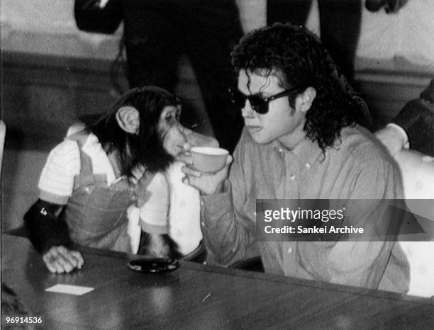 Singer Michael Jackson enjoys a cup of tea with his pet Bubbles at Osaka City Mayoral Hall on September 18, 1987 in Osaka, Japan.