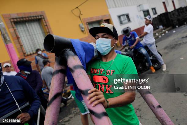 An anti-government demonstrator carries a makeshift mortar during protests in the town of Masaya, 35 km from Managua on June 5, 2018. - From little...