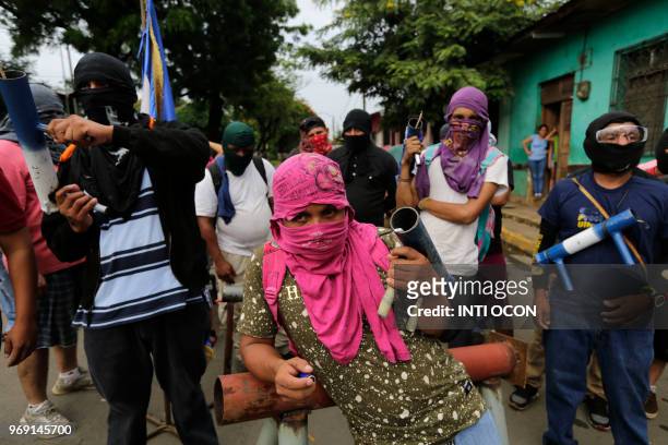 Anti-government demonstrators carry hand-made mortars, as they stand near a barricade during protests in the town of Masaya, 35 km from Managua on...