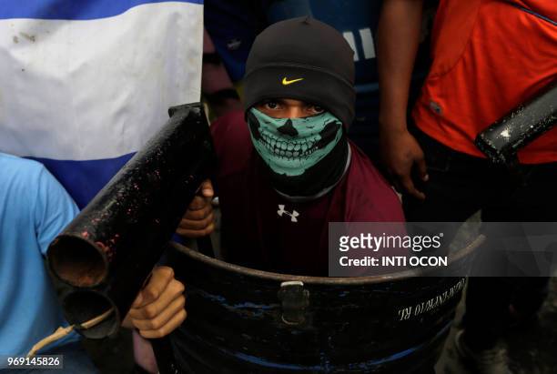 An anti-government demonstrator holds a makeshift mortar during protests in the town of Masaya, 35 km from Managua on June 5, 2018. - From little...