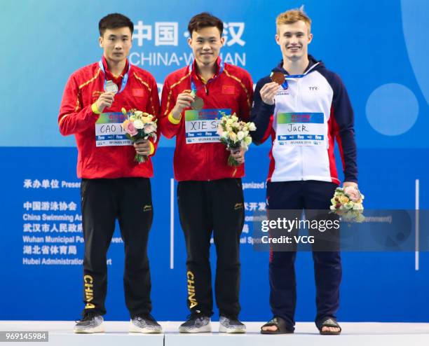 Silver medallist Cao Yuan of China, gold medallist Xie Siyi of China and bronze medallist Jack Laugher of Great Britain pose on the podium after the...