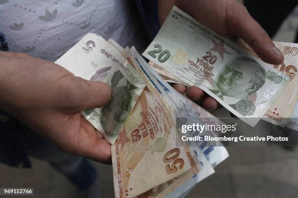 a customer counts turkish lira banknotes - turkish lira stock pictures, royalty-free photos & images