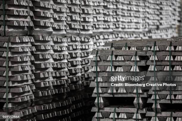 bound aluminum ingots sit stacked in a warehouse - aluminium ingots stockfoto's en -beelden