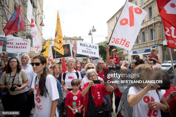 People hold banners during a protest to support Nicole Briend, an activist of the Association for the Taxation of Financial Transactions and for...