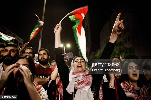Woman shouts a slogan while waving a Jordanian national flag during a demonstration against a draft income tax law near the prime minister's office...