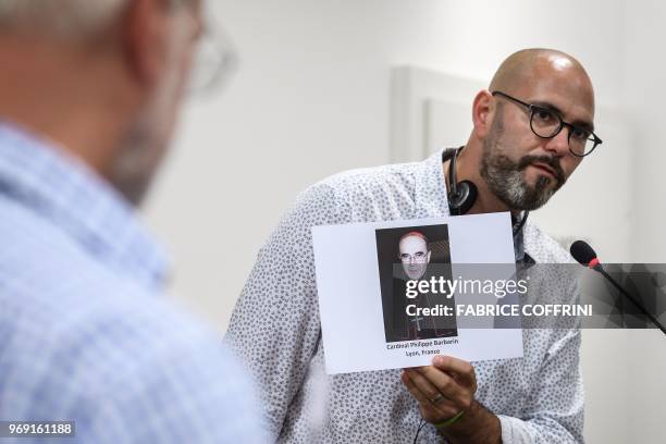 President of French association 'La parole Liberee' Francois Devaux holds a picture of French cardinal Philippe Barbarin during a press conference of...