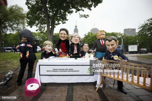 Activists wear masks in the likeness of Giuseppe Conte, Italy's prime minister, from left, Angela Merkel, Germany's chancellor, Justin Trudeau,...