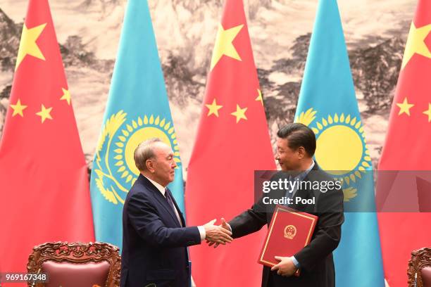 Kazakhstan's President Nursultan Nazarbayev shakes hand with Chinese President Xi Jinping during a signing ceremony in the Great Hall of the People...