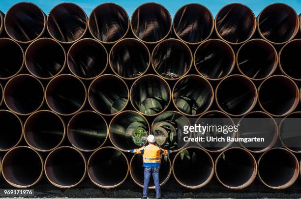 Large pipes for the Baltic Sea pipeline Nord Stream 2 on a storage area in the ferry port of Sassnitz/Neu Mukran. An employee of the responsible...
