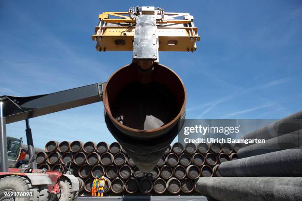 Large pipes for the Baltic Sea pipeline Nord Stream 2 on a storage area in the ferry port of Sassnitz/Neu Mukran - Terminal Truck stacks the pipes....