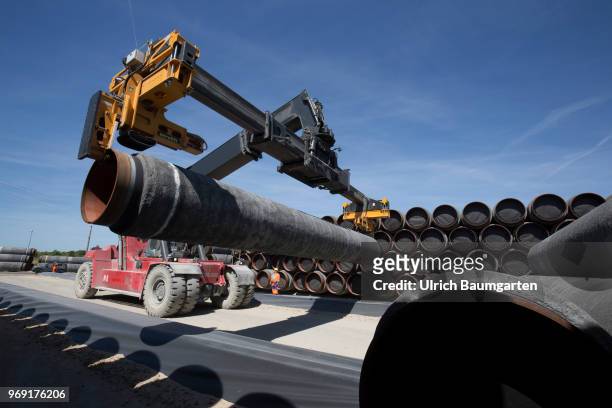 Large pipes for the Baltic Sea pipeline Nord Stream 2 on a storage area in the ferry port of Sassnitz/Neu Mukran - Terminal Truck stacks the pipes....