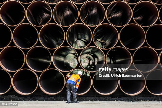 Large pipes for the Baltic Sea pipeline Nord Stream 2 on a storage area in the ferry port of Sassnitz/Neu Mukran. An employee of the responsible...