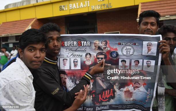Supporters of actor Rajnikant pose with a poster of Kaala movie as the film releases world-wide, at Balaji theatre on June 7, 2018 in Bengaluru,...