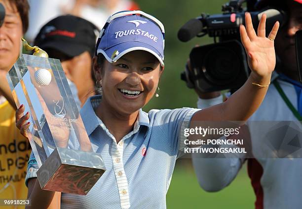 Ai Miyazato of Japan waves to fans as he holds with winner's trophy following her victory in the final round of the Golf Honda PTT LPGA Thailand 2010...