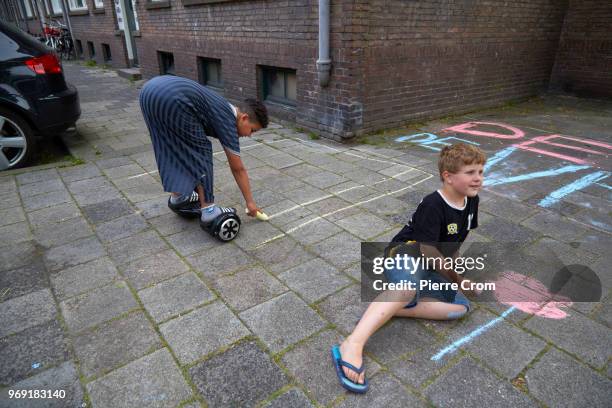 Children draw on the pavement outside the Laleli Mosque on June 7, 2018 in Rotterdam, Netherlands.The anti-Islam group Pegida plans to roast pigs on...