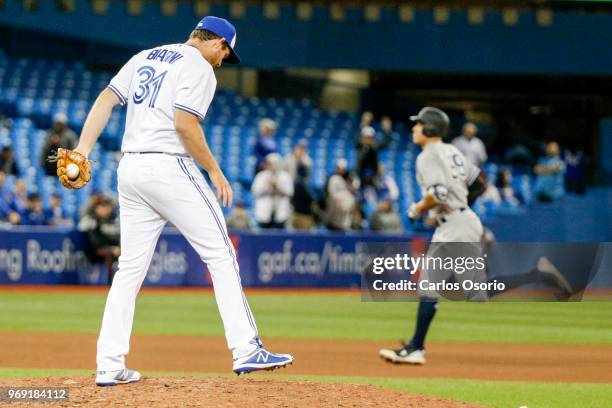 Pitcher Joe Biagini of the Blue Jays is seen on the mound while Aaron Judge of the Yankees rounds the bases after hitting a solo home run during the...