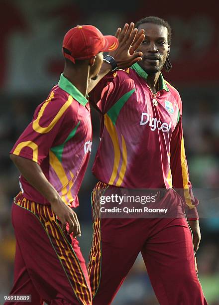 Chris Gayle of the West Indies is congratulated by a team-mate after getting a wicket during the Twenty20 International match between Australia and...