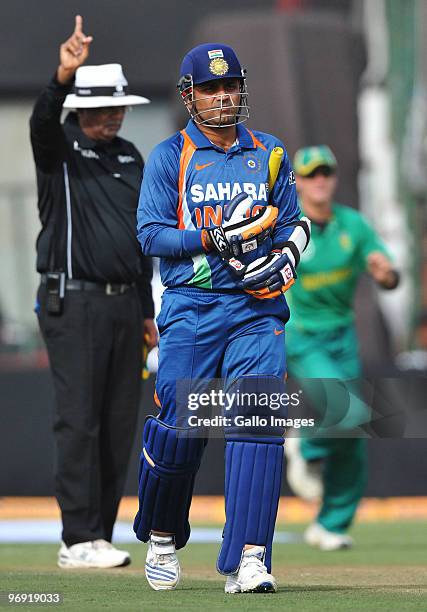 Virender Sehwag of India walks off after being run out off a deflection by bowler Charl Langeveldt of South Africa during the First One Day...