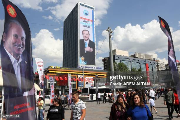 People walk next to banners reading "president of all of us" of Muharrem Ince, Presidential candidate of Turkey's main opposition Republican People's...