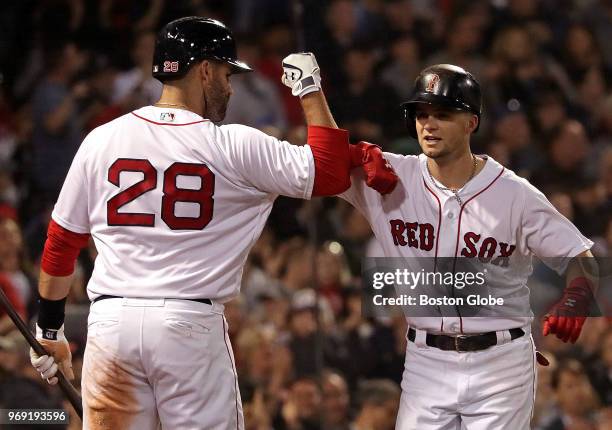 Boston Red Sox left fielder Andrew Benintendi gets a arm bump from Boston Red Sox right fielder J.D. Martinez after his solo home run in the fifth...