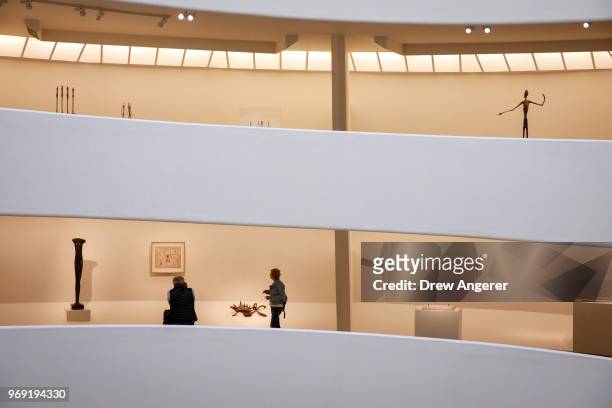Visitors walk through a retrospective exhibition of work by Swiss sculptor and artist Alberto Giacometti at the Guggenheim Museum, June 7, 2018 in...