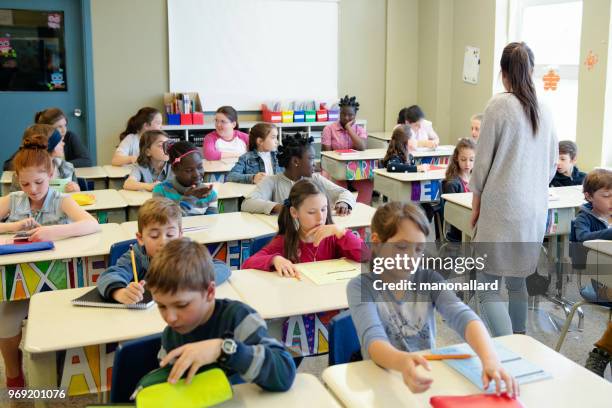 estudiantes multiétnicos sentarse en la clase para el primer día en la escuela - niño-en-edad-escolar fotografías e imágenes de stock