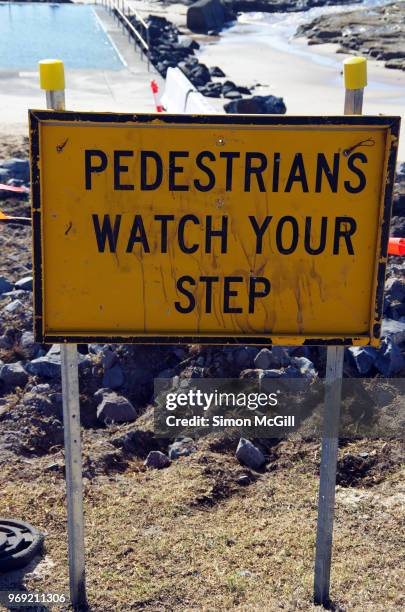 'pedestrians watch your step' sign near a construction site near a beach - trip hazard stock pictures, royalty-free photos & images