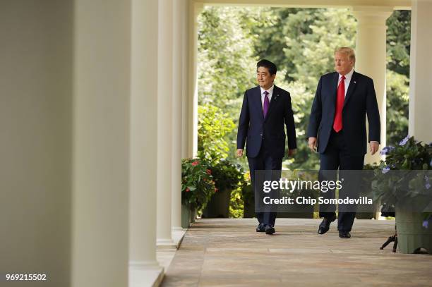 Japanese Prime Minister Shinzo Abe and U.S. President Donald Trump walk along the Rose Garden colonnade as they arrive for a joint news conference at...