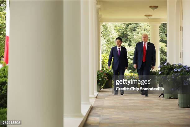 Japanese Prime Minister Shinzo Abe and U.S. President Donald Trump walk along the Rose Garden colonnade as they arrive for a joint news conference at...