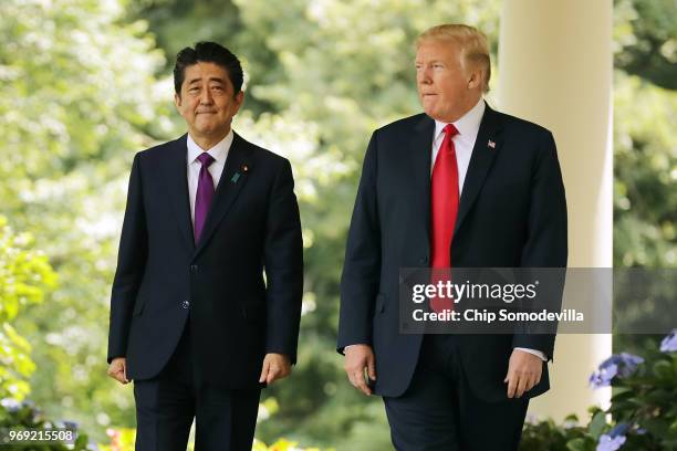 Japanese Prime Minister Shinzo Abe and U.S. President Donald Trump walk along the Rose Garden colonnade as they arrive for a joint news conference at...